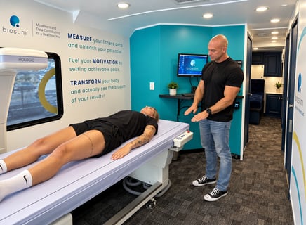 A biosum specialist talking a client through a DEXA scan inside the mobile lab